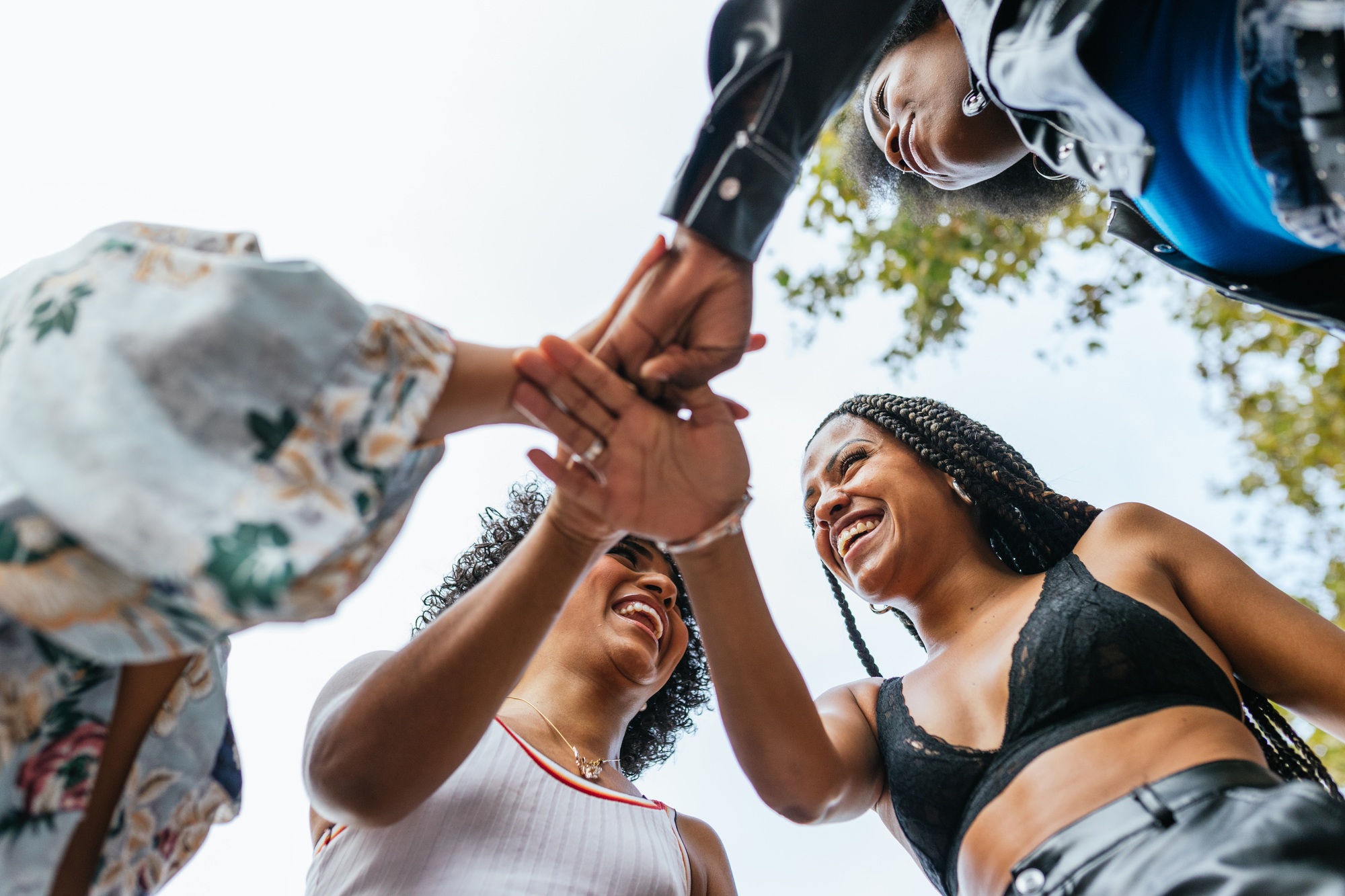 women joining hands, celebrating diversity and inclusion